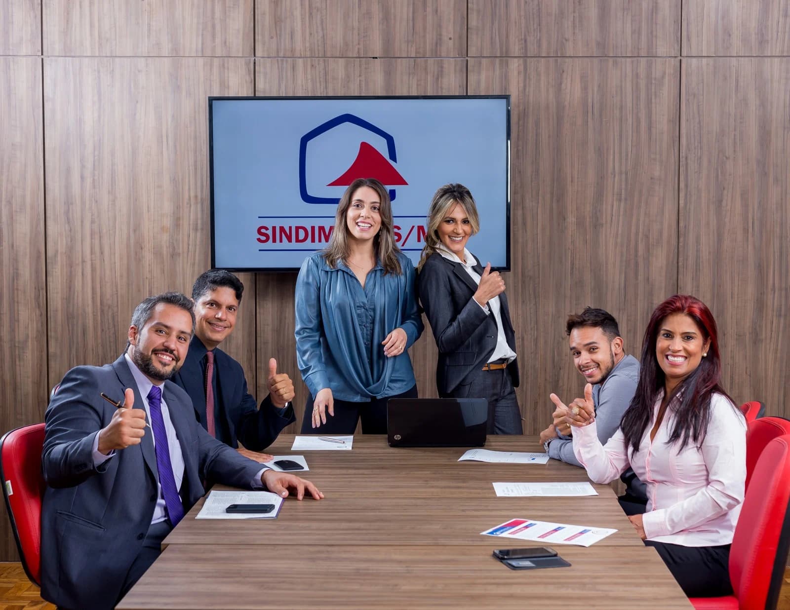 Grupo reunido com a marca Sindimóveis MG ao fundo